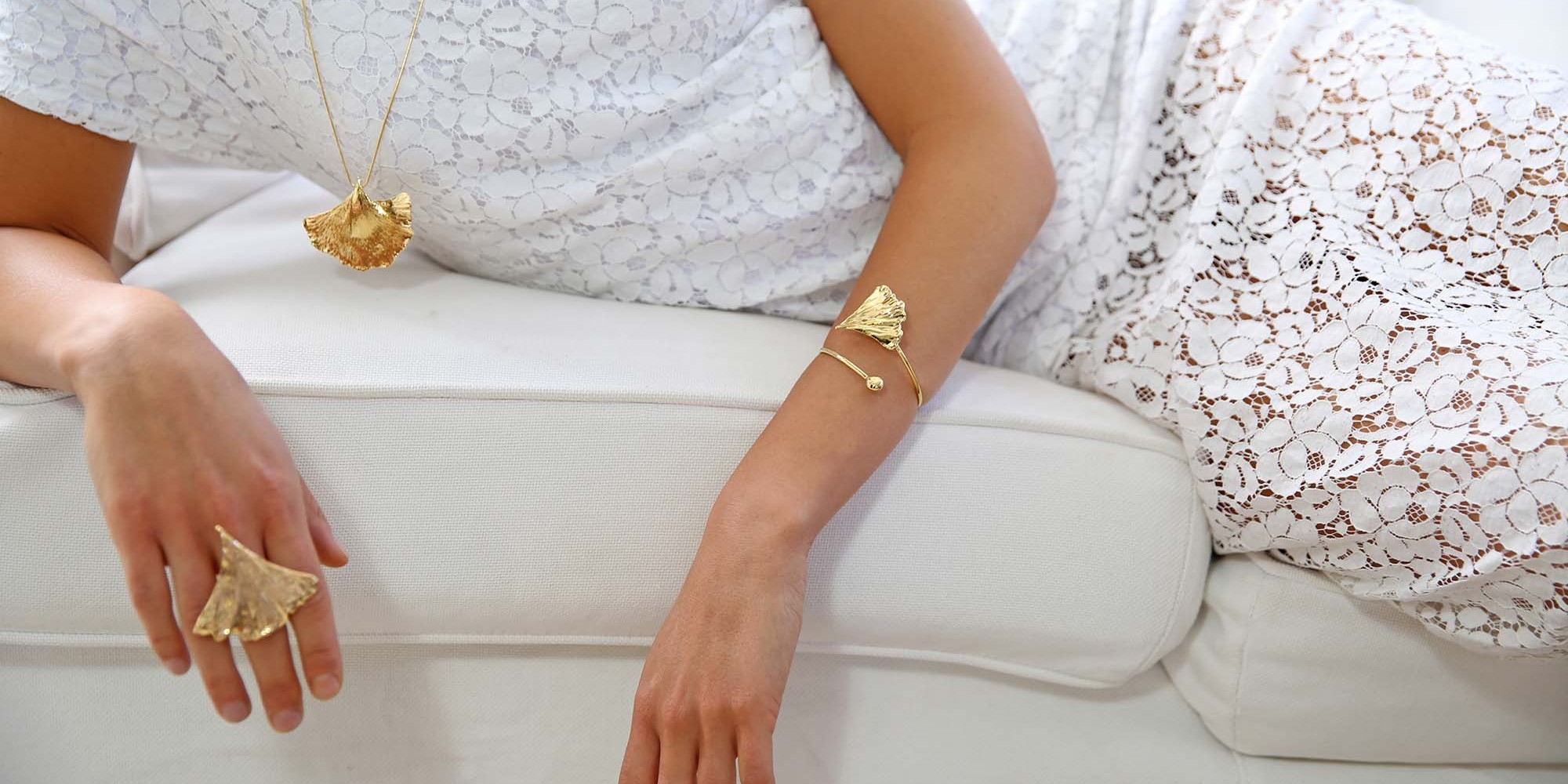 Parure indossata da modella con ciondolo, anello e bracciale di vere foglie di ginkgo biloba placcate oro